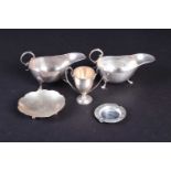 A small group of silver items, comprising two sauce boats, a miniature trophy, a small ashtray and a