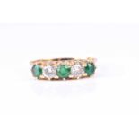 A five stone half hoop emerald and diamond ring, the round brilliant cut diamonds and circular cut