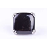 An onyx and diamond dress ring by Gavello, the cushion shaped onyx plaque secured with pear-