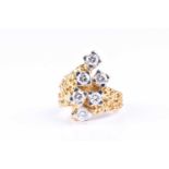 A modern abstract six stone diamond ring, the round brilliant cut diamonds in squared four claw