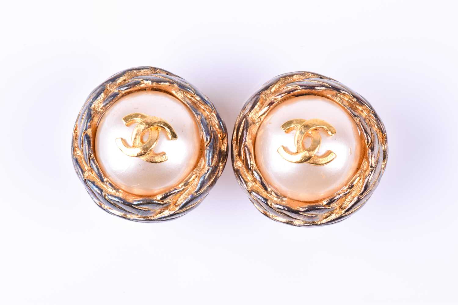 A pair of vintage Chanel earrings, the faux pearls bearing gilt metal CC logo within a woven