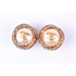 A pair of vintage Chanel earrings, the faux pearls bearing gilt metal CC logo within a woven