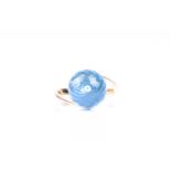 A blue topaz dress ring, the multi-faceted spherical topaz in plain ploished cross-over mount marked