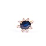 A sapphire cluster ring, the horizontally set four claw mounted sapphire within a border of eight