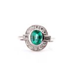 A platinum, diamond, and emerald ring, set with a mixed oval-cut emerald of approximately 1.25