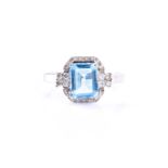 A 9ct white gold, diamond, and blue topaz cocktail ring, set with a mixed rectangular-cut topaz,
