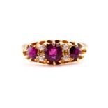 A yellow metal, diamond, and ruby ring, set with three mixed round-cut rubies and four small diamond