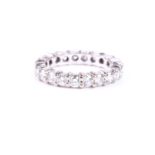 A diamond full hoop eternity ring, the round brilliant cut diamonds in flattenend claw mounts to
