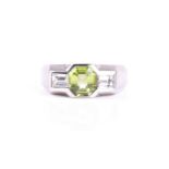 A three stone half hoop diamond and peridot ring, the octagonal step cut peridot flanked with