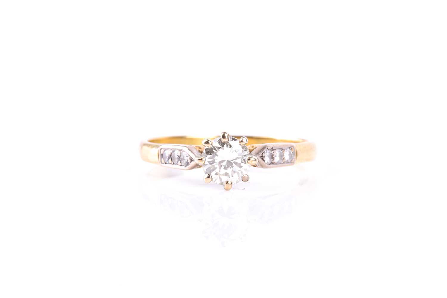 A single stone diamond ring, the round brilliant cut diamond in eight claw mount to three stone
