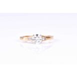 A three stone half hoop diamond ring, the central round brilliant cut diamond in simple four claw