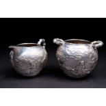 A Chinese silver sugar bowl and cream jug, late 19th century, the cauldron shape bowl repousse