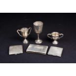 A small collection of silver items, including three cigarette boxes and two miniature trophies and a