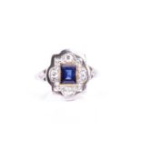 A sapphire and diamond cluster ring, the principle rectangular step-cut sapphire in rub-over mount