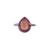 A late 19th / early 20th century ruby and glass ring, the teardrop-shaped mount with lightly