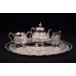 An Indian white metal three-piece teaset and conforming oval tray, 20th century, each decorated with