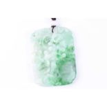 A carved jade pendant, the rounded rectangular panel carved and pierced with layered fruiting and