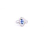 An 18ct white gold, diamond, and sapphire ring set with a marquise-cut blue sapphire of