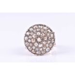 A diamond cluster ring, the large circular plaque pave set with rose diamonds, to a pierced and