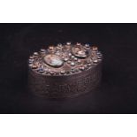 A late 19th century French white metal table snuff box of oval form, the hinged cover with crowned