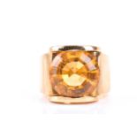 A single stone citrine dress ring, the large circular mixed cut citrine, with styksed scroll mounts,