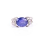 A diamond and tanzanite ring, the double loop shoulders pave-set with round brilliant-cut