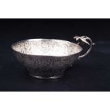A Continental white metal embossed bowl, the scroll handle with bird surmount, indistinct stamped