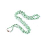 A single strand graduated mottled green jade bead necklace, to a seven stone diamond clasp, clasp