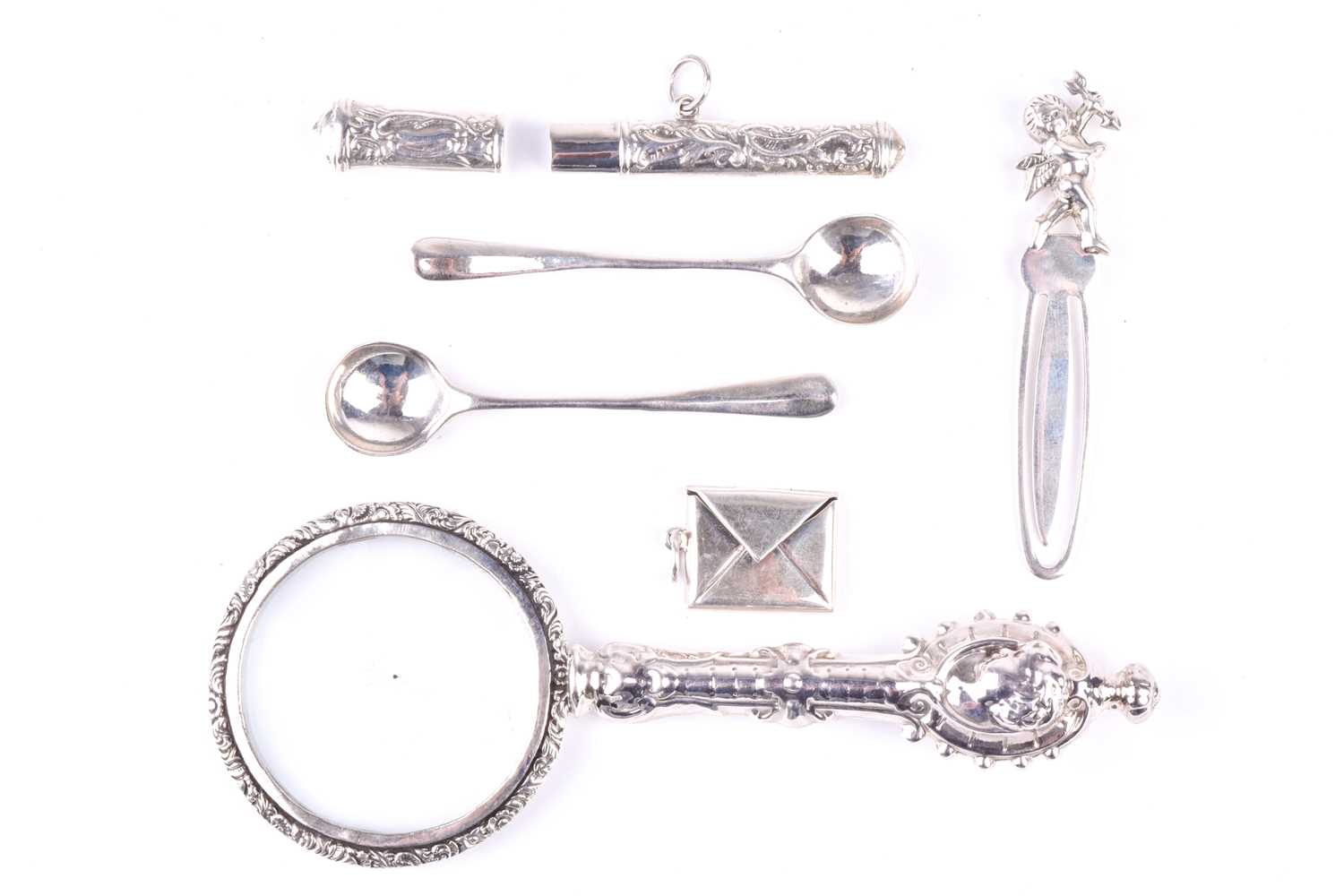 A white metal mounted magnifying glass, with cherub decoration, together with a pair of silver