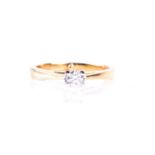 A single stone diamond ring, the round brilliant cut diamond in raised four claw mount, to tapered