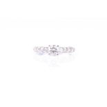 A single stone diamond ring, the round brilliant cut diamond in four claw mount, above slightly