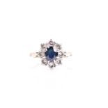 A sapphire and diamond cluster ring, the central oval cut blue sapphire within a border of eight