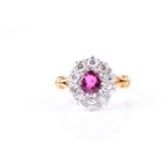 A ruby and diamond cluster ring, the oval cut ruby claw mounted within a border of brilliant cut