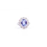 An 18ct white gold, diamond, and tanzanite cluster ring, set with a mixed oval-cut tanzzanite of