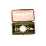 An early 20th century yellow metal ladies wristwatch, with white enamel Roman numeral dial, the