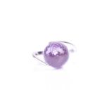An amethyst dress ring, the multi-faceted spherical amethyst in plain polished cross-over mount