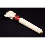 A Russian carved ivory parasol handle, well carved as a dog's head with ruby inset eyes set in