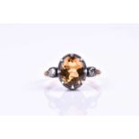 An unusual citrine and diamond ring, the silver collet mounts inset with a mixed oval-cut citrine,