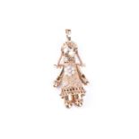 An articulated 9ct gold rag doll pendant, the artculated figure set with clear and coloured glass,