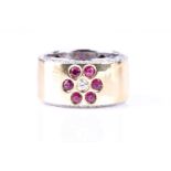 An 18ct white and yellow band ring, inlaid with a diamond ruby floral design, with diamonds to the