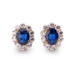 Garrards. A fine pair of diamond and sapphire cluster earrings, each set with a mixed oval-cut
