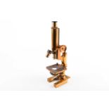 A monocular microscope by R & J Beck Ltd, lacquered brass with fixed platform, numbered 24938,