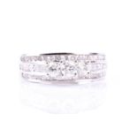 A diamond ring, the three principle brilliant cut diamonds claw mounted above three rows of