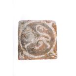 A medieval encaustic tile, 13th century, decorated in off white slip on a terracotta ground, a