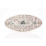 An Art Deco diamond and aquamarine brooch of elongated oval form, the openwork mount set with rose-
