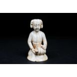 A Chinese walrus ivory carving of a drummer girl, 18th century, in the Tang style, modelled kneeling