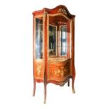 A French style serpentine fronted glazed vitrine display cabinet, having gilt ormolu decoration,