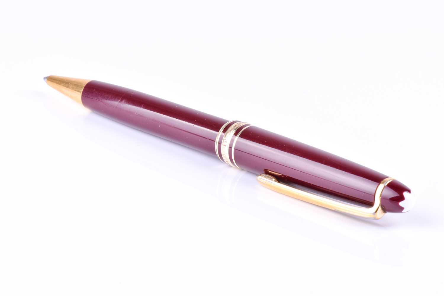 A Montblanc Meisterstuck ballpoint pen, with maroon coloured resin body and cap, and gilt metal