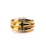 An 18ct yellow gold, diamond, and emerald dress ring, the stylised rounded mount inset with a row of