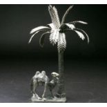 A continental white metal camel and palm tree, 20th century, on rectangular base, 591g, 24cm
